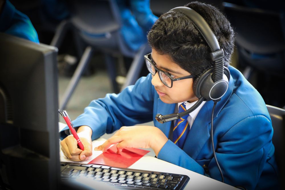 Boy wearing headphones studying in the language lab